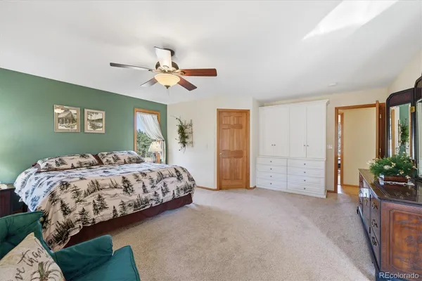 a spacious bedroom with a balcony a bed and a chandelier