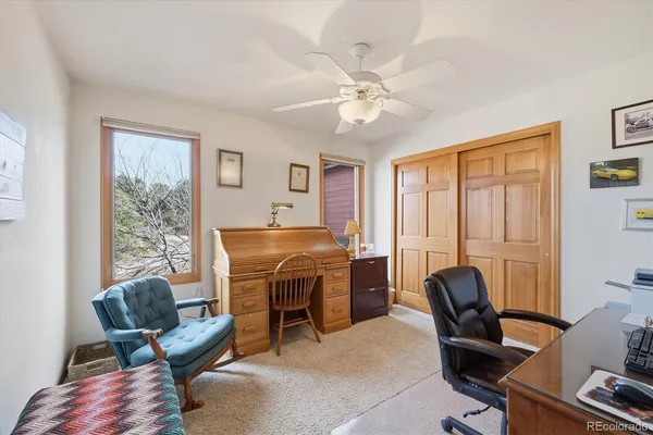 a view of a workspace with furniture and a window