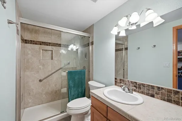 a bathroom with a granite countertop sink toilet and shower
