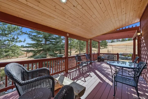 a roof deck with table and chairs and wooden floor