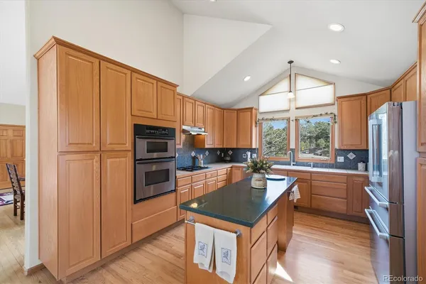 a kitchen with stainless steel appliances a refrigerator a stove a sink and a microwave