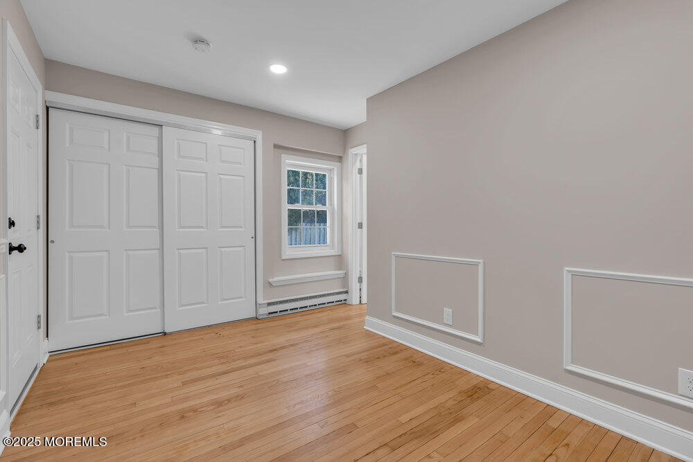 609 Higgins Avenue, Unit 3 Brielle, NJ 08730 - Photo 16 of 25 an empty room with wooden floor and windows