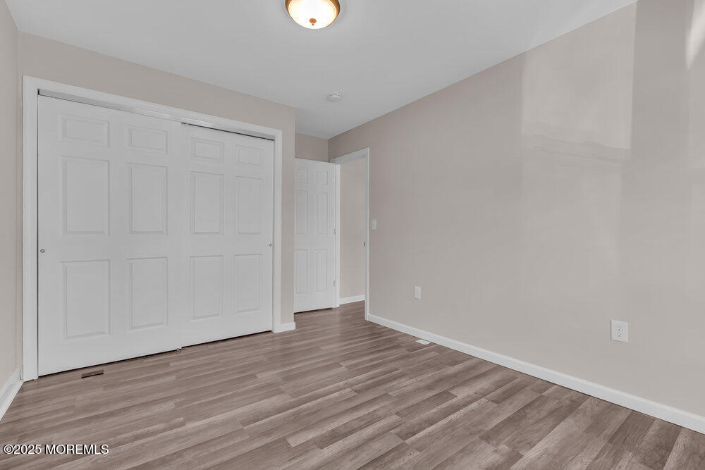 609 Higgins Avenue, Unit 3 Brielle, NJ 08730 - Photo 18 of 25 a view of an empty room with wooden floor