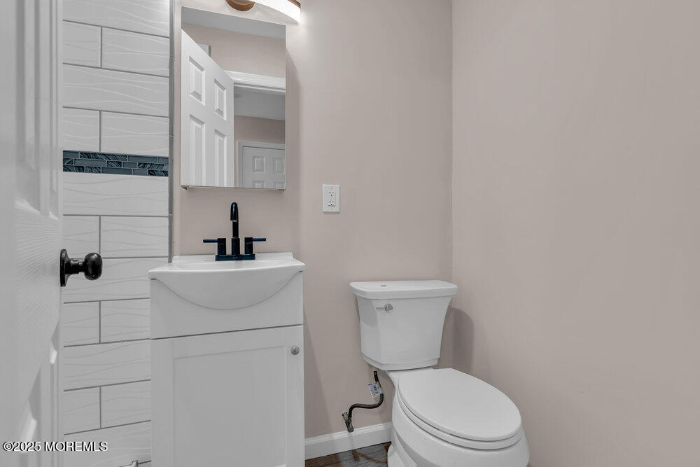609 Higgins Avenue, Unit 3 Brielle, NJ 08730 - Photo 22 of 25 a bathroom with a toilet sink and mirror