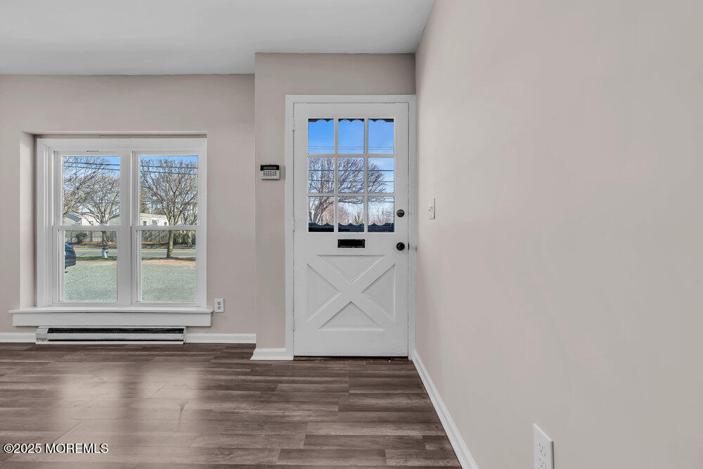 609 Higgins Avenue, Unit 3 Brielle, NJ 08730 - Photo 4 of 25 a view of a hallway with wooden floor and a cabinet
