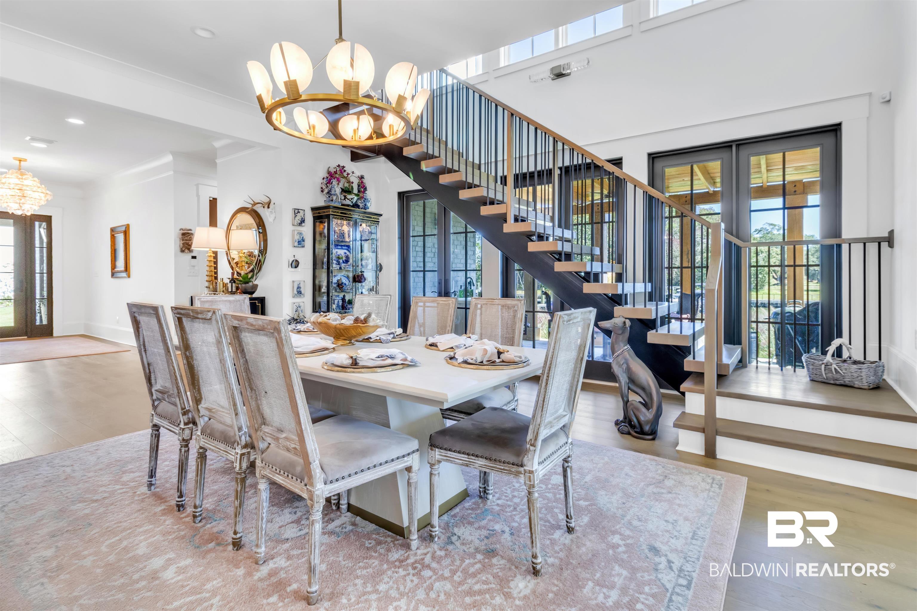 885 Inlet Circle Gulf Shores, AL 36542 - Photo 10 of 36 Dining room featuring french doors, a notable chandelier, plenty of natural light, and hardwood / wood-style floors