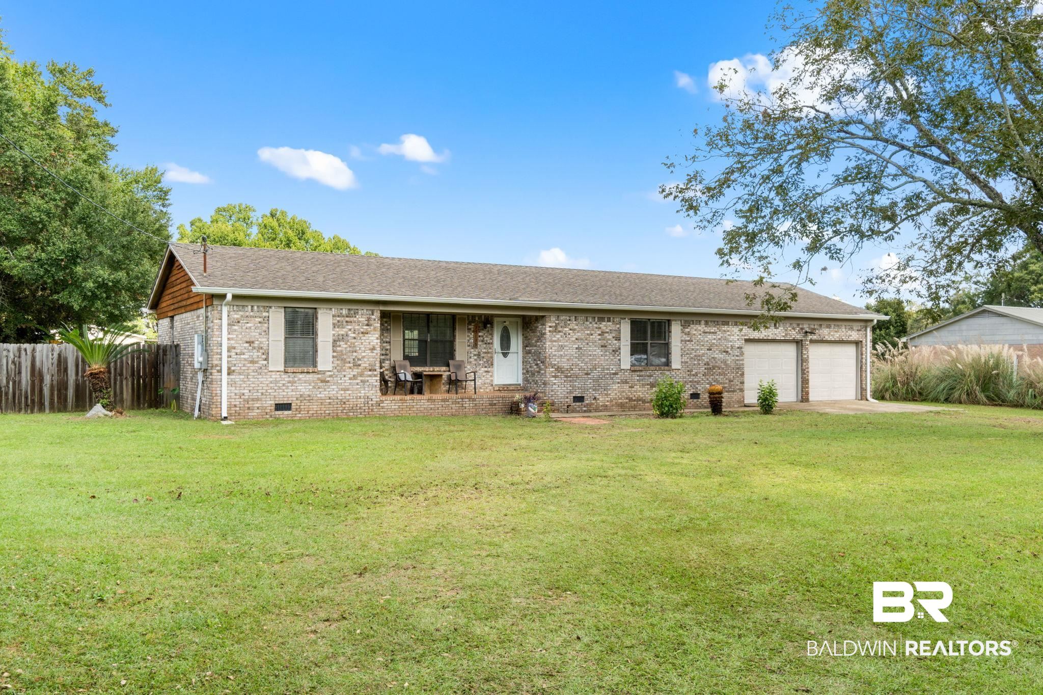 33135 Collier Road Lillian, AL 36549 - Photo 2 of 30 Single story home with crawl space, brick siding, concrete driveway, a garage, and a porch