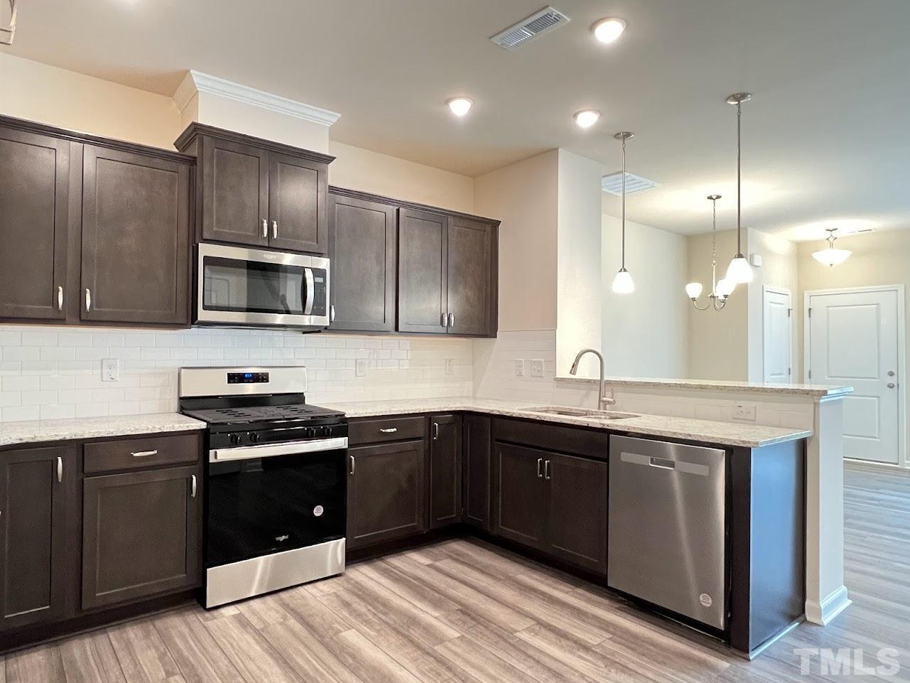 4812 Trikala Avenue Raleigh, NC 27603 - Photo 2 of 16 a kitchen with a sink stove and microwave