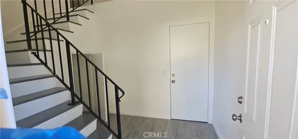 a view of staircase with wooden floor and white walls