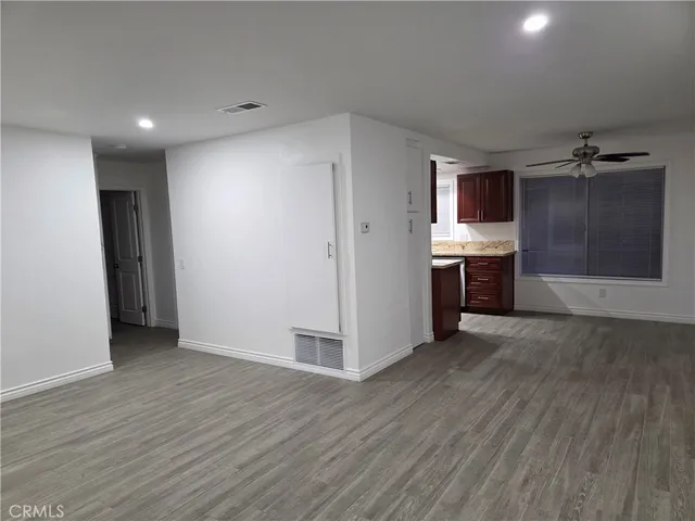 a view of empty room with wooden floor