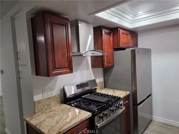 a kitchen with wooden cabinets and a stove top oven