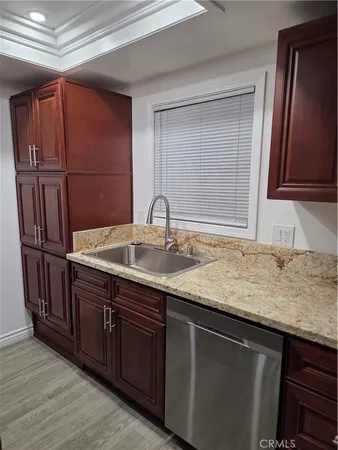a kitchen with stainless steel appliances granite countertop a sink and wooden cabinets