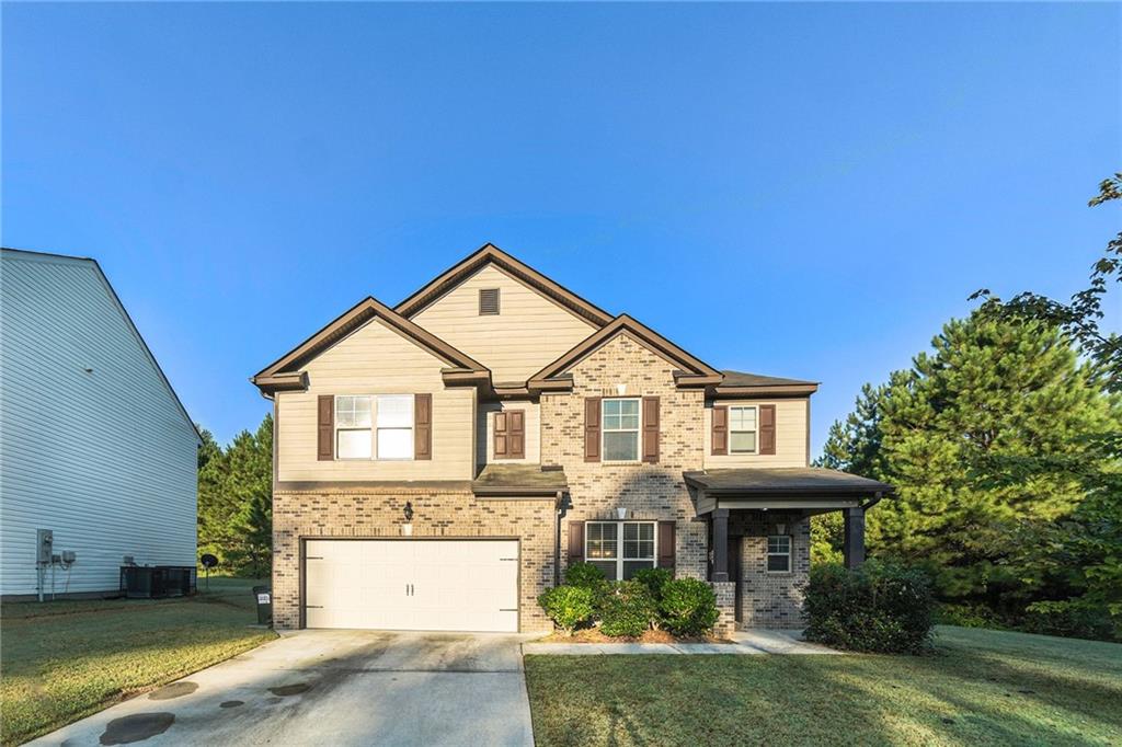 5615 Wisbech Way Atlanta, GA 30349 - Photo 1 of 1 a front view of a house with a yard and garage