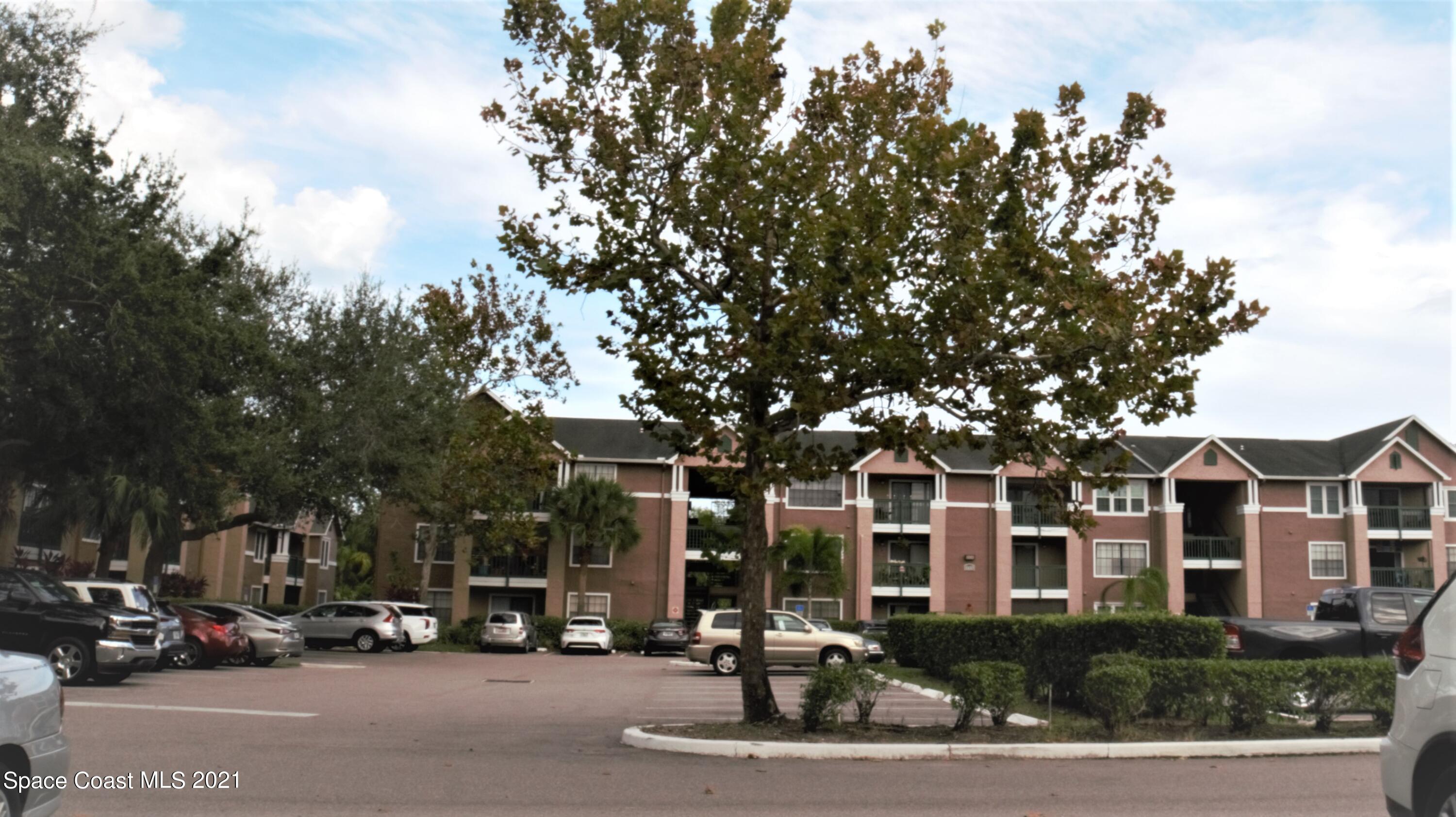 7667 North Wickham Road, Unit 1309 Melbourne, FL 32940 - Photo 4 of 18 a building with trees in front of it