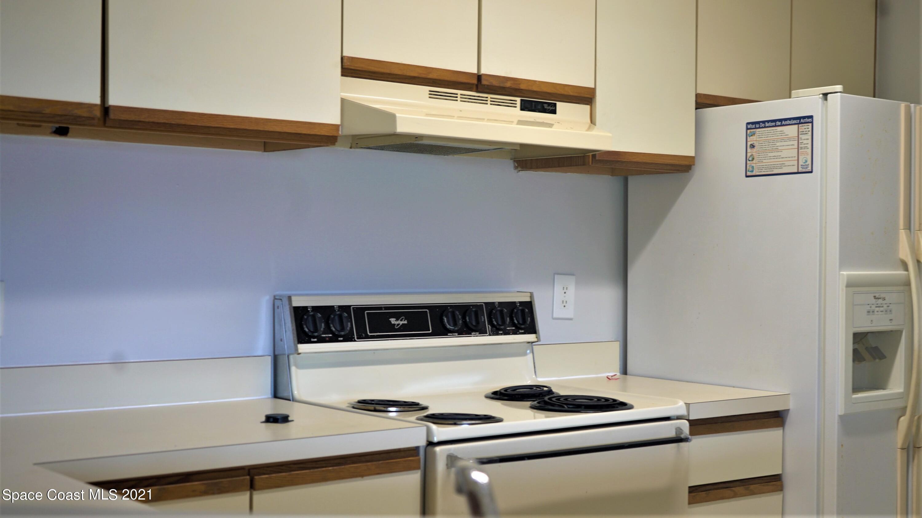 7667 North Wickham Road, Unit 1309 Melbourne, FL 32940 - Photo 6 of 18 a kitchen with stainless steel appliances a stove and a microwave