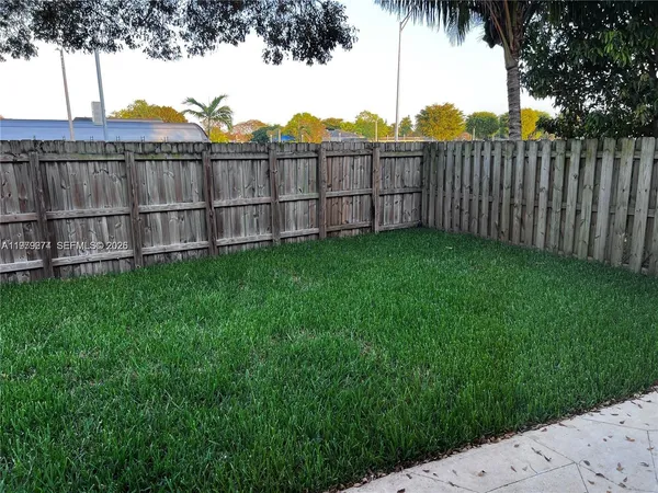 a view of a wooden fence with a big yard