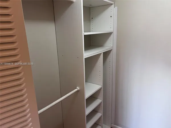 a view of walk in closet with empty racks