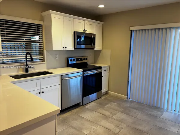 a kitchen with a sink stove and microwave
