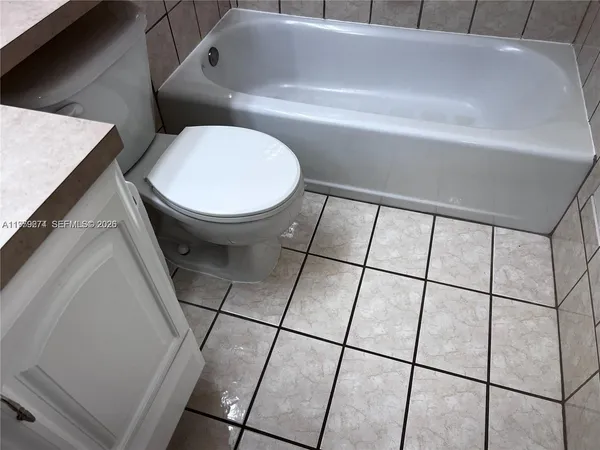 a view of an empty room with wooden floor and closet