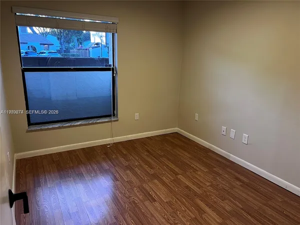 a view of an empty room with wooden floor