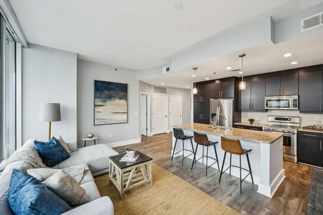 a kitchen with stainless steel appliances granite countertop a refrigerator a stove a sink and a microwave