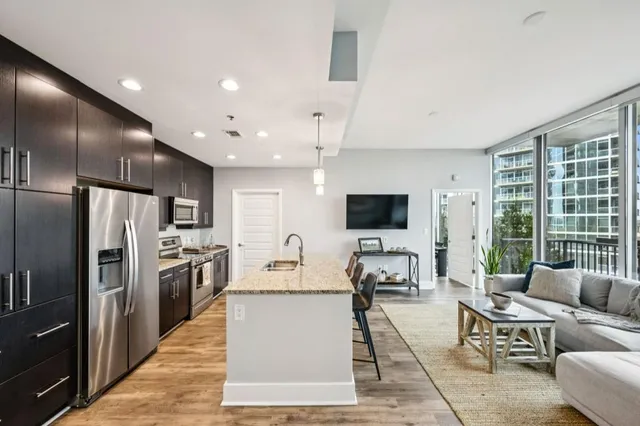 a hall with kitchen island granite countertop a couch and a view of living room