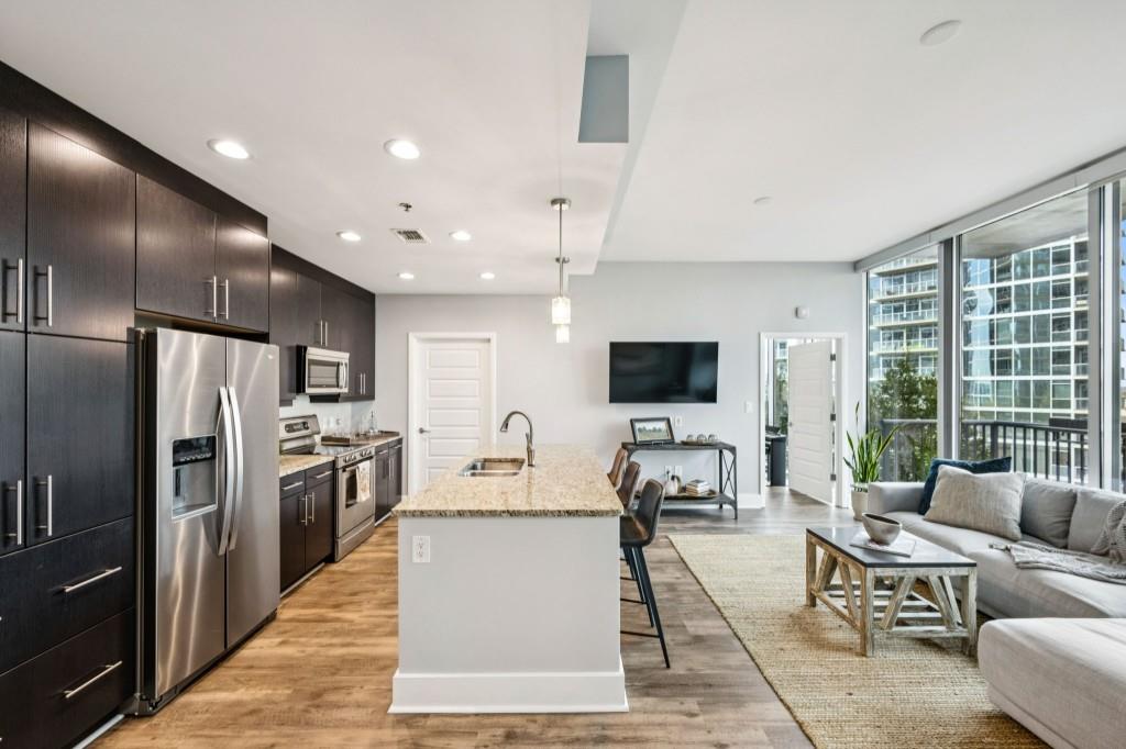 1080 Peachtree Street Northeast, Unit 1012 Atlanta, GA 30309 - Photo 17 of 46 a living room with furniture a large window and a flat screen tv