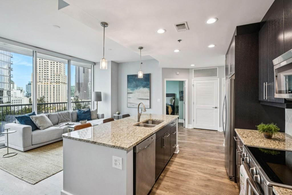 1080 Peachtree Street Northeast, Unit 1012 Atlanta, GA 30309 - Photo 18 of 46 a hall with kitchen island granite countertop a couch and a view of living room
