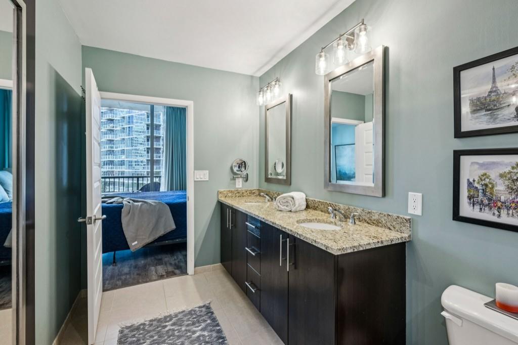 1080 Peachtree Street Northeast, Unit 1012 Atlanta, GA 30309 - Photo 19 of 46 a en suite bathroom with a granite countertop sink and a mirror