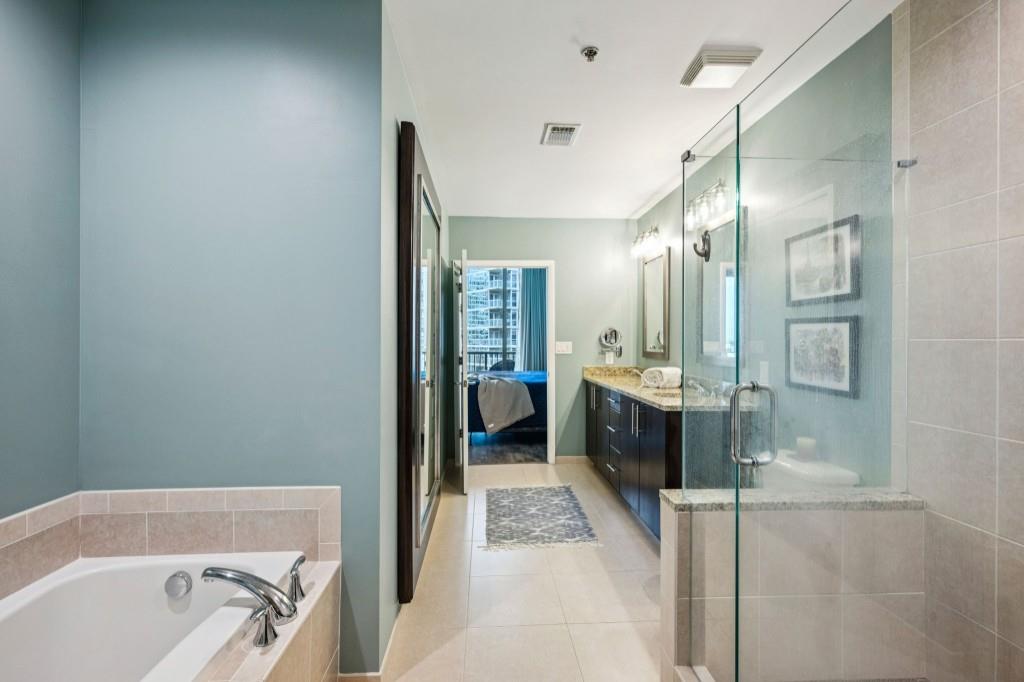 1080 Peachtree Street Northeast, Unit 1012 Atlanta, GA 30309 - Photo 21 of 46 a bathroom with a tub a sink and a large mirror
