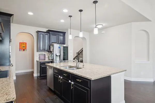 a kitchen with stainless steel appliances granite countertop a sink a refrigerator and a stove