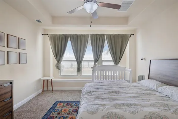 a bedroom with a bed and a large window