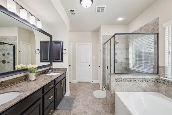 a bathroom with a granite countertop sink mirror and a bathtub