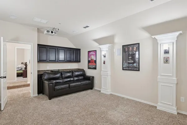 a living room with furniture and a refrigerator