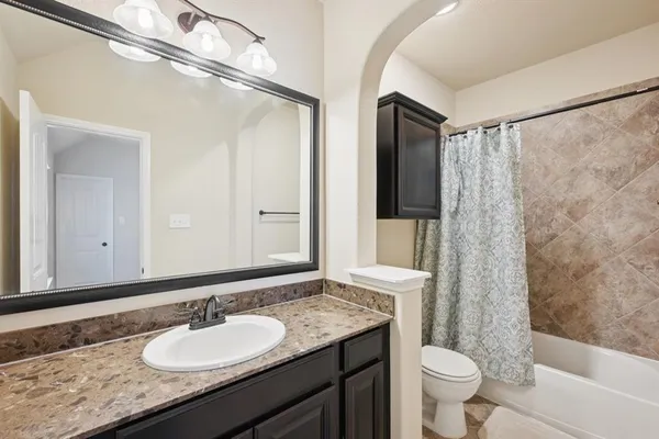 a bathroom with a granite countertop sink toilet and shower