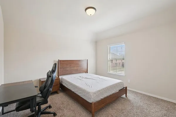 a bedroom with a bed and a desk