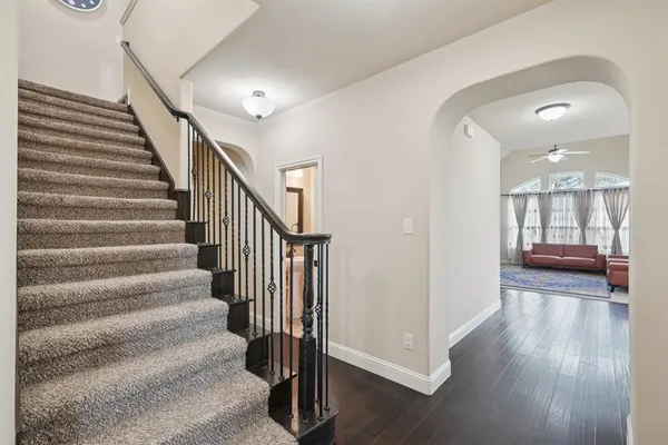 a view of a hallway with wooden floor and staircase