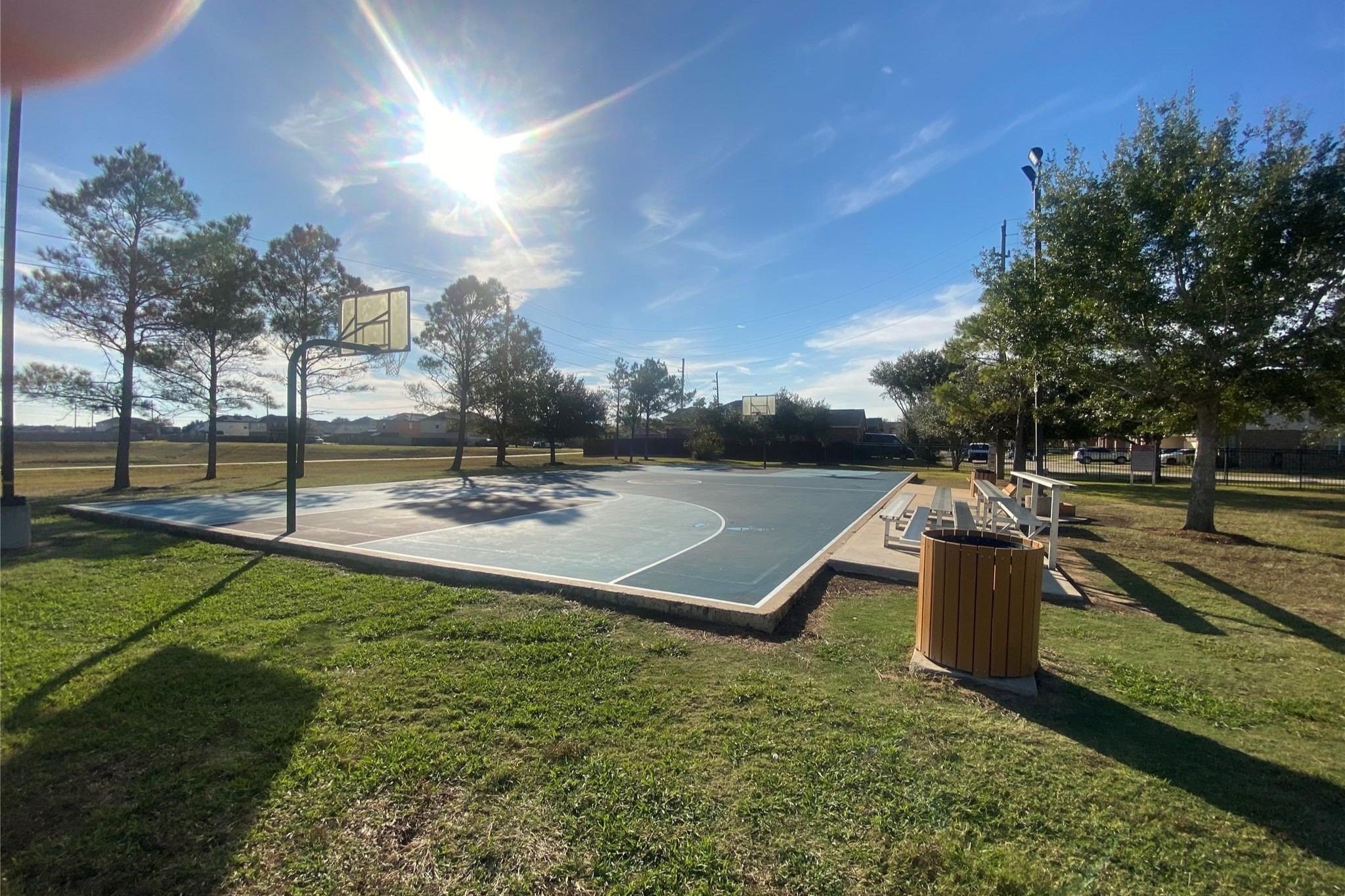 8310 Rose Petals Lane Rosharon, TX 77583 - Photo 35 of 37 Community basketball court in Southern Colony, featuring a full outdoor court with hoops and nearby seating for spectators. Surrounded by open green space and mature trees, this recreational area offers residents a great place to play, exercise, and enjoy the outdoors.
