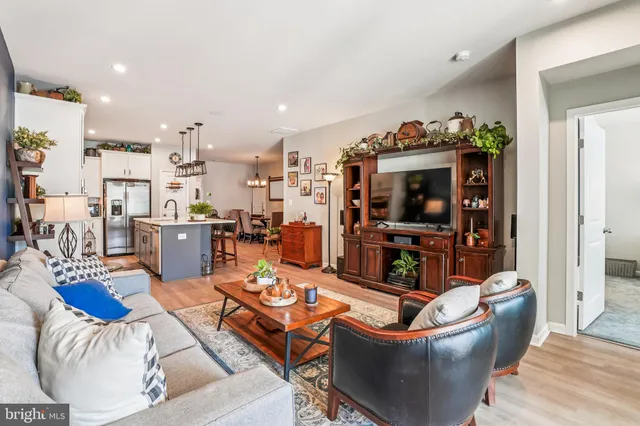 a living room with furniture and view of kitchen