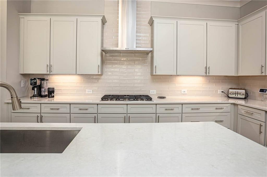255 Old Town Road Dacula, GA 30019 - Photo 18 of 38 a kitchen with granite countertop white cabinets and stainless steel appliances