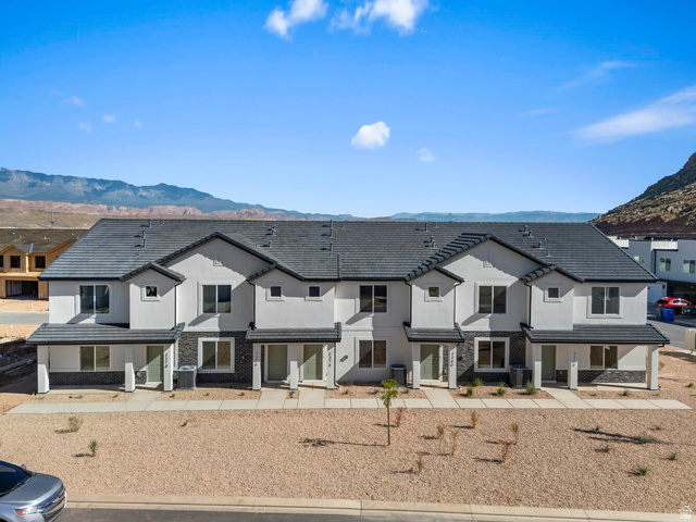 2194 Wolverine Way, Unit 2531 Washington, UT 84780 - Photo 2 of 52 Contemporary townhome facade featuring light stucco, dark stone accents, and a dark shingle roof