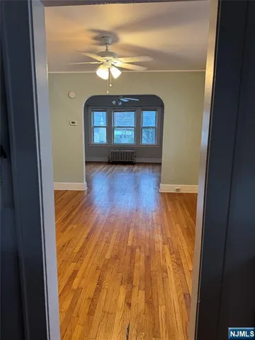 a view of a room with wooden floor and entryway