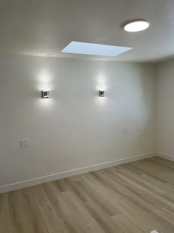 a view of a livingroom with wooden floor and a ceiling fan
