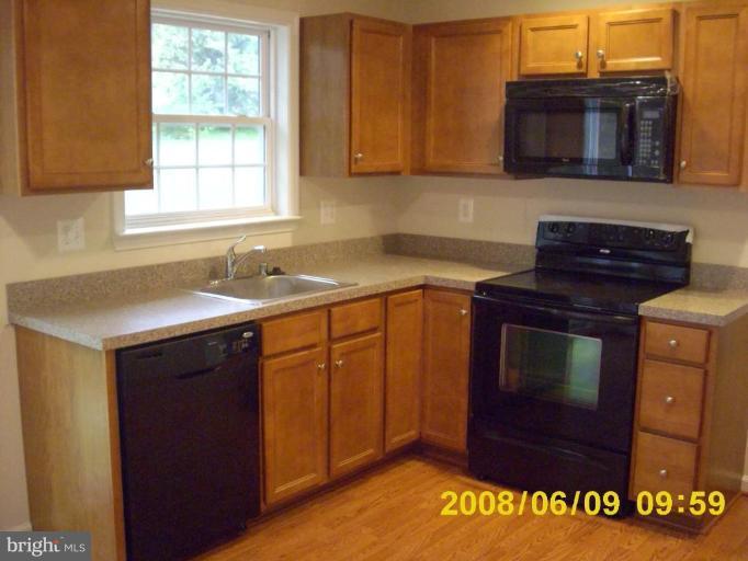 5628A Oakland Road, Unit A Halethorpe, MD 21227 - Photo 4 of 6 a kitchen with a stove and a microwave