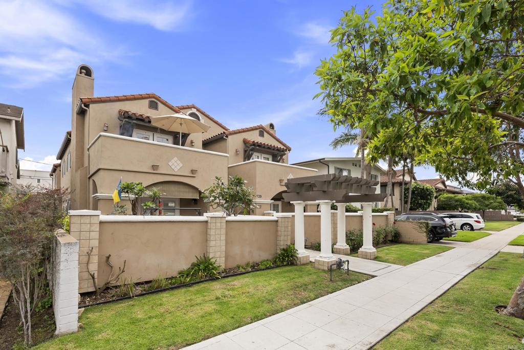 535 F Avenue, Unit 4 Coronado, CA 92118 - Photo 2 of 48 a view of a white house next to a yard with big trees