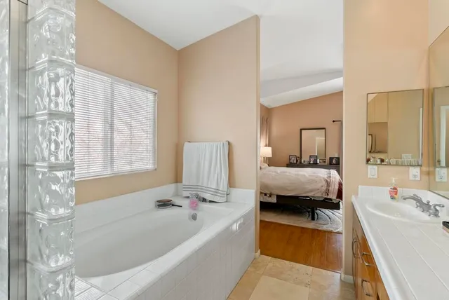 a bathroom with a double vanity sink toilet mirror and bathtub