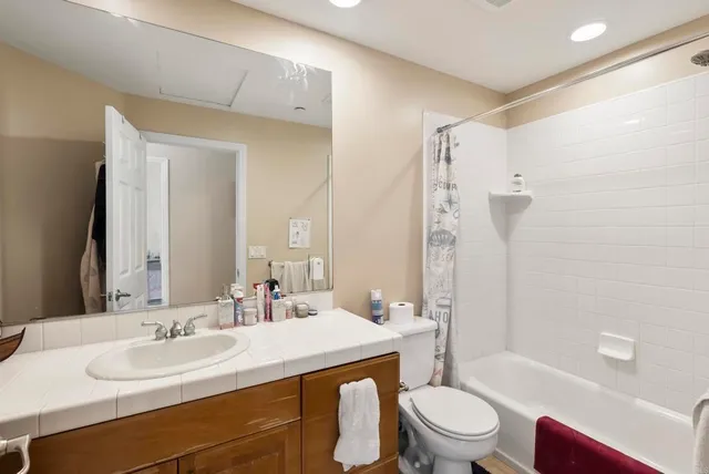 a spacious bathroom with a double vanity sink a large mirror and a bathtub