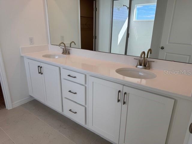 17727 Sharp Pummelo Alley Winter Garden, FL 34787 - Photo 16 of 19 a bathroom with double sink and a mirror