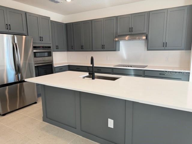 17727 Sharp Pummelo Alley Winter Garden, FL 34787 - Photo 6 of 19 a kitchen with stainless steel appliances a sink a stove a refrigerator and cabinets