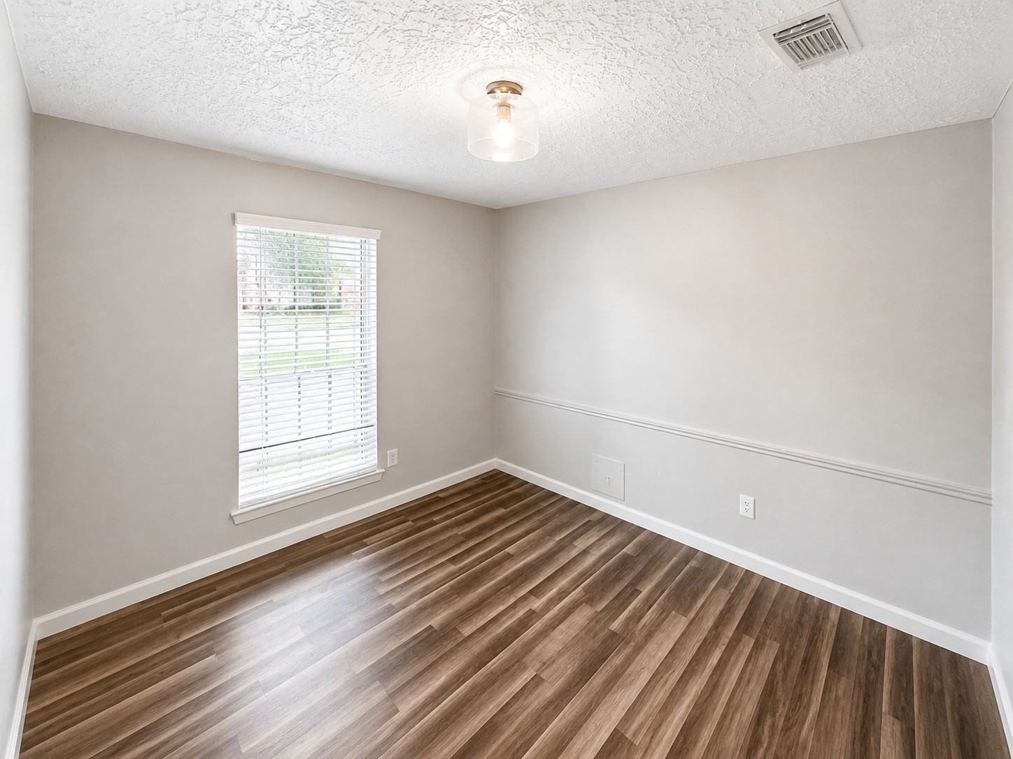15950 Chimney Rock Road Missouri City, TX 77489 - Photo 6 of 9 an empty room with wooden floor and windows